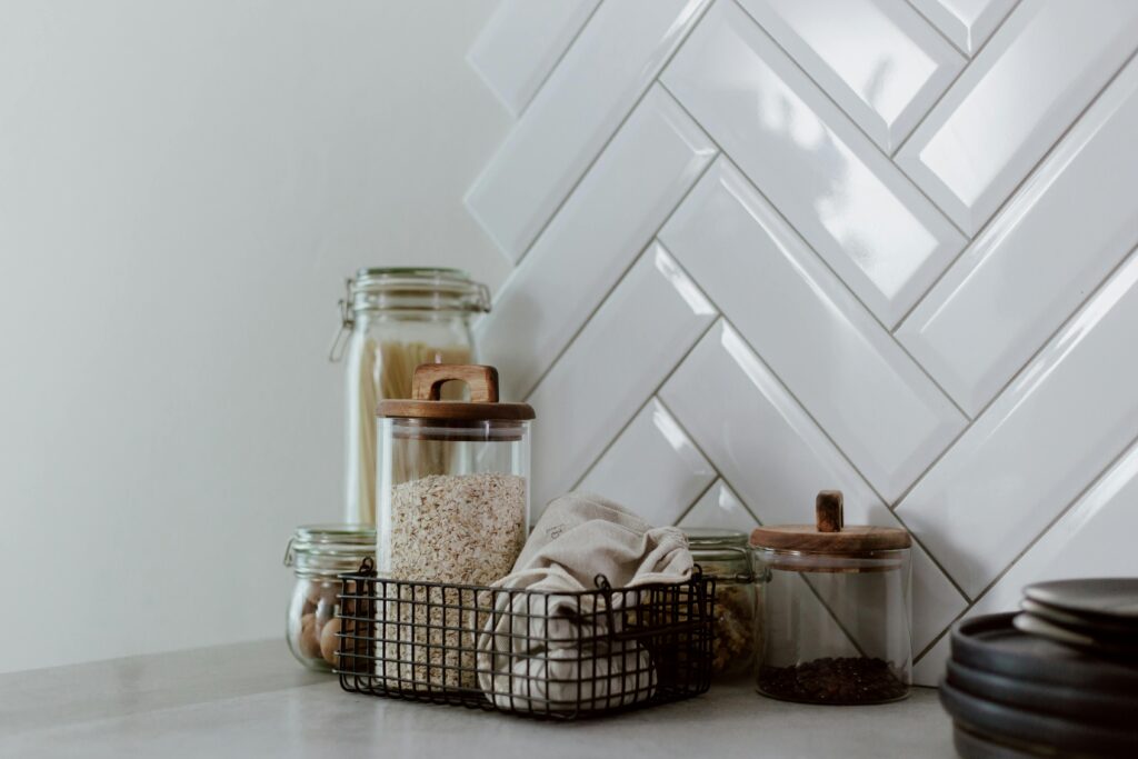 Stylish kitchen setup featuring glass jars with pasta and grains on a clean counter.