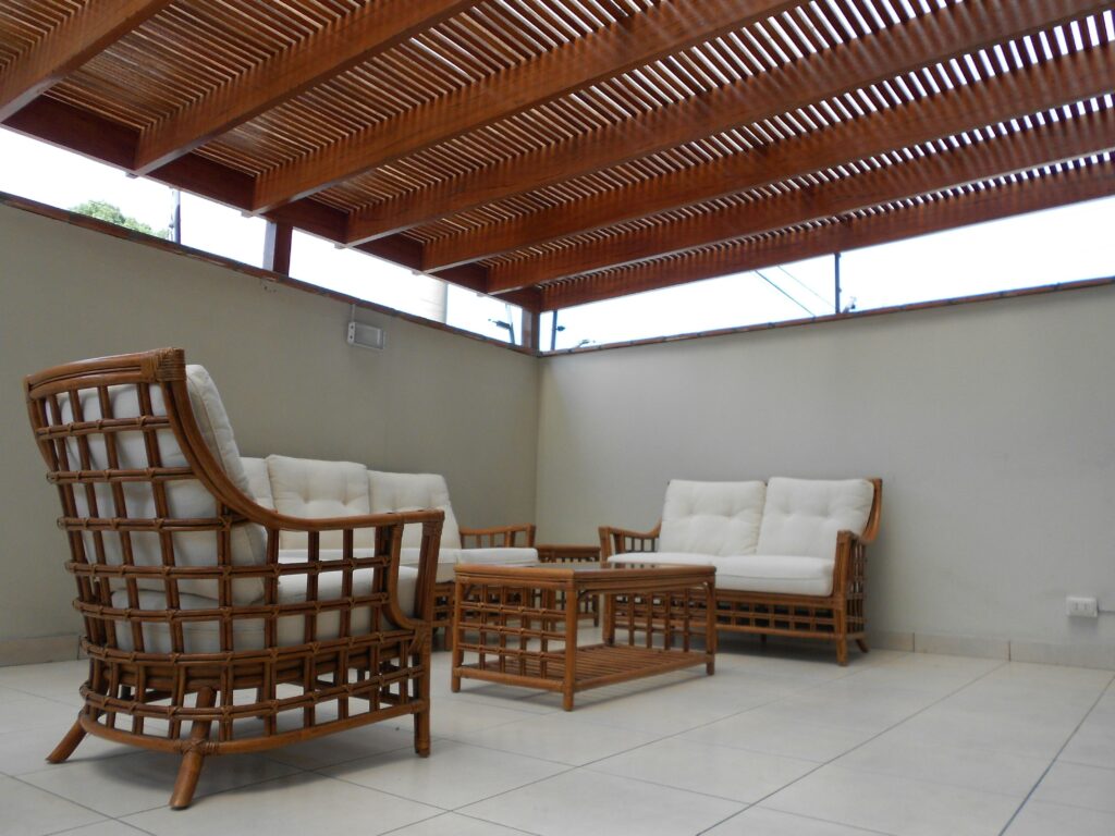 Stylish outdoor patio with rattan chairs and a wooden pergola, perfect for relaxation.