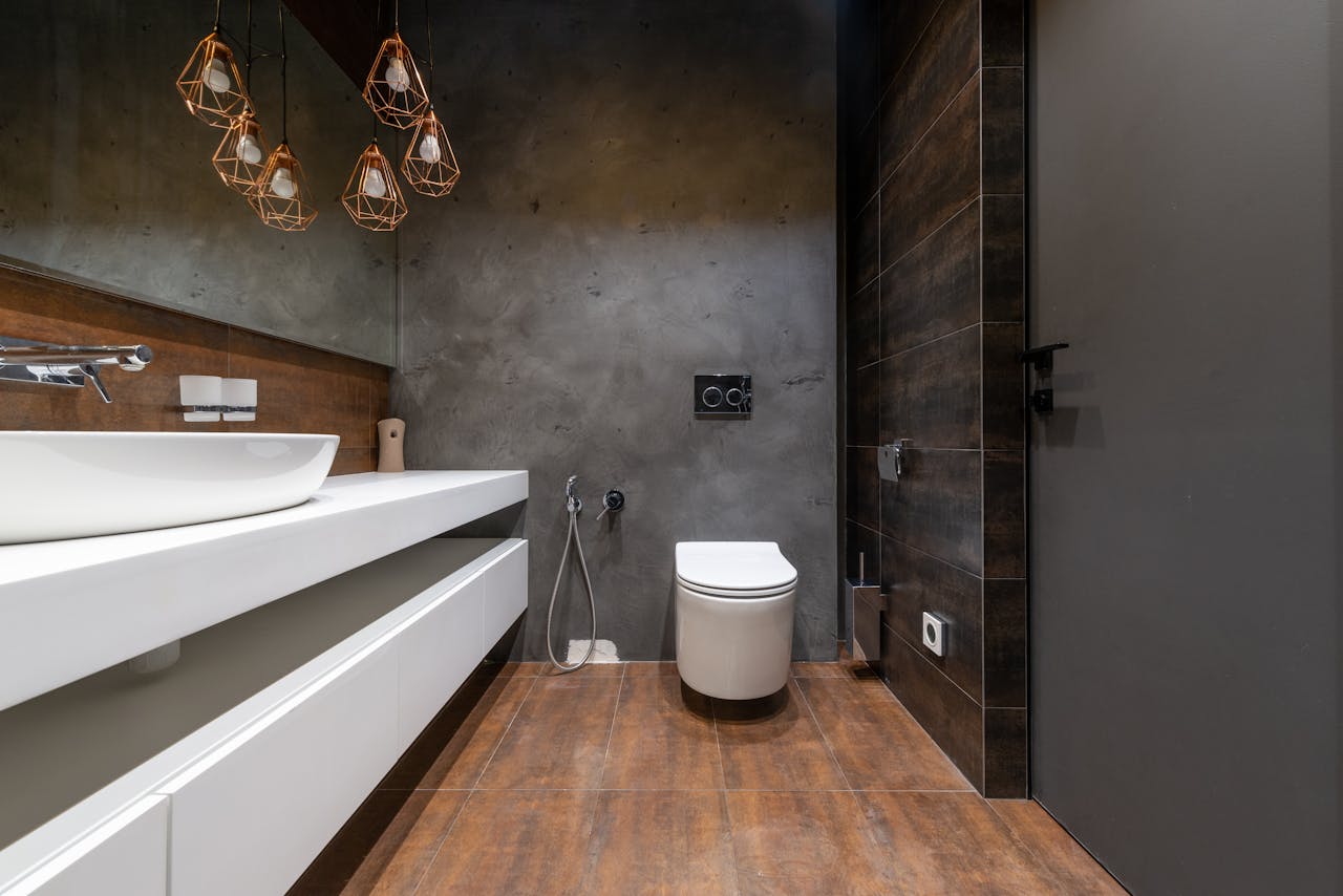 Sleek modern bathroom featuring a minimalist sink and elegant hanging lights.